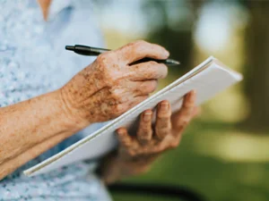 Person tracking their symptoms on a piece of paper | Working with your healthcare team