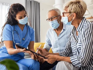 Patient and their companion talking to heathcare provider in a hospital setting