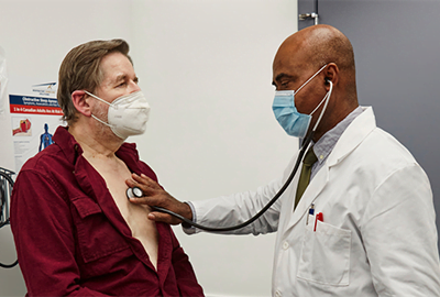 Doctor using stethoscope on patient